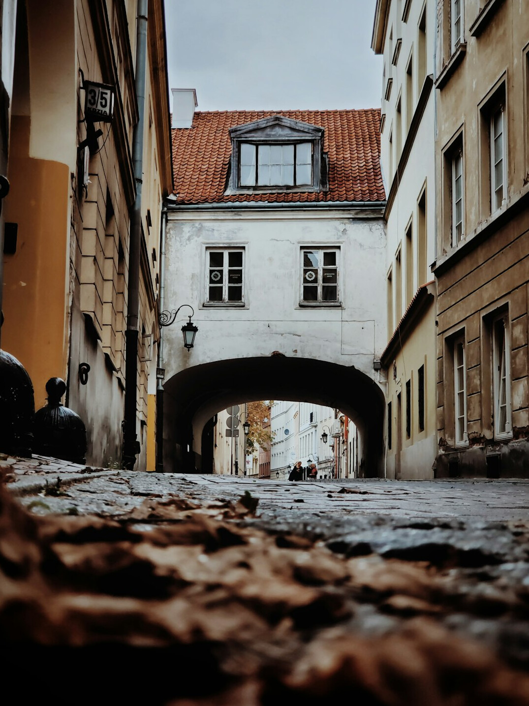 Documentary photographer walking through a narrow street in a small Polish town